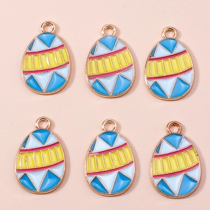 Macro detail of six colorful enamel easter egg charms with golden frames and patterns