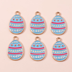 Detail of blue enamel Easter egg charms with heart patterns for DIY jewelry making