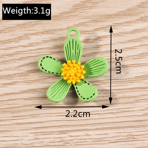 Detail view of a 3.1g green alloy flower pendant with 2.5cm height on wood
