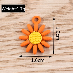 Macro shot of orange sunflower charm with measurements 1.9cm x 1.6cm and grid texture
