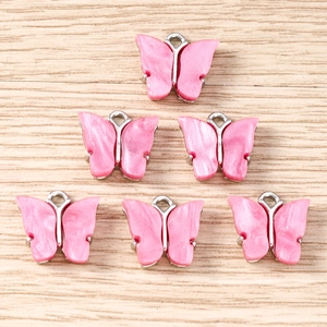 Detailed view of pink acrylic butterfly pendants with silver metal frames and hooks