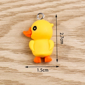 Detail of yellow duck charm with size dimensions 2.7cm by 1.5cm on wooden background