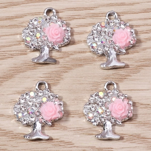 Dettaglio di ciondoli albero della vita con strass e rosa in resina rosa per gioielli fai da te