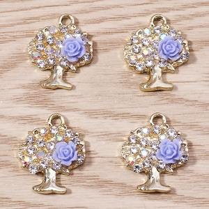 Dettaglio macro dei ciondoli Albero della Vita con rose in resina viola e strass lucidi