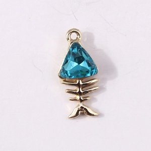 Détail macro d'un pendentif arête de poisson avec pierre bleue et finition en métal doré