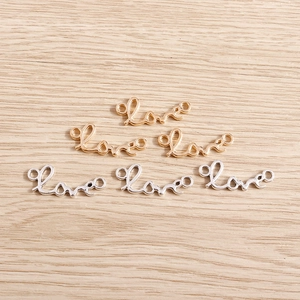 Gold- und Silber-Legierungsanhänger Love für DIY-Halsketten auf einem Holzuntergrund