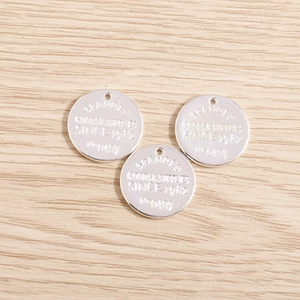 Set of three round silver metal geometric pendants with embossed alphabet and number details