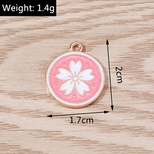Detail view of a 2cm pink cherry blossom enamel charm with dimensions and 1.4g weight info