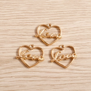 Detailed macro view of three golden heart Love pendants for DIY jewelry making