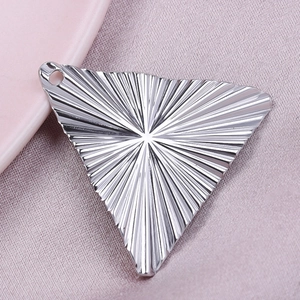 Macro detail of 304 stainless steel triangle pendant with radial sunburst texture