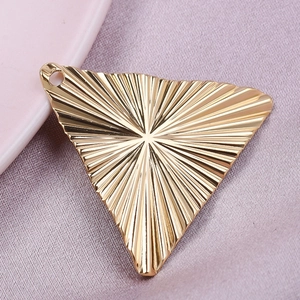 Macro detail of golden 304 stainless steel triangle pendant with sunburst stripe pattern