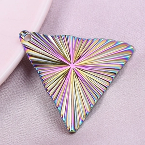 Macro view of rainbow plated triangle pendant with vintage 18k gold striped sunburst texture