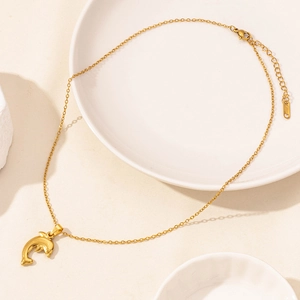 Makro-Detail einer goldenen Delfin-Halskette mit Karabinerverschluss und verstellbarer Kette