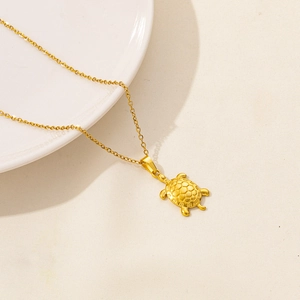 Collana minimalista dorata con ciondolo a tartaruga e guscio geometrico traforato
