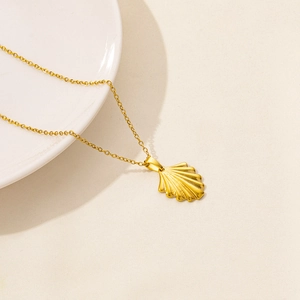Dettaglio macro della collana con ciondolo a conchiglia dorata e catena a O
