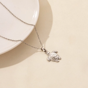 Detailaufnahme der silbernen Schildkröten-Halskette mit Seestern- und Muschelstruktur