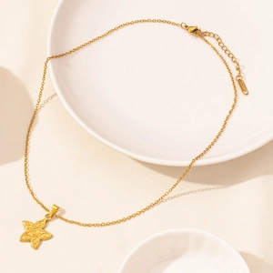 Elegante collana in acciaio inossidabile dorato con ciondolo a stella su piatto in ceramica