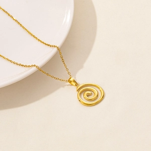 Nahaufnahme der goldenen Spiral-Halskette auf minimalistisch strukturiertem Grund