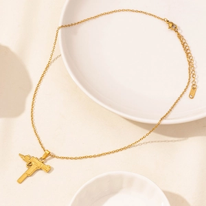 Collana in acciaio inossidabile dorato con pendente Uzi su piatto bianco
