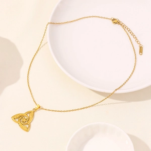 Dettaglio ravvicinato della collana dorata in acciaio inossidabile con nodo celtico