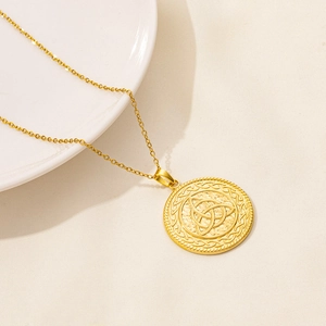 Dettaglio della collana con ciondolo a nodo celtico dorato con trama martellata e bordo