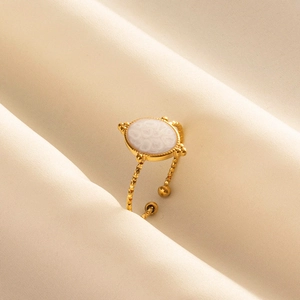 Bague ouverte dorée avec pierre de marbre blanc sur tissu en soie beige chic