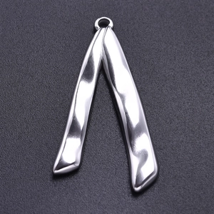 Macro detail of irregular V-shape silver stainless steel pendant with wavy texture