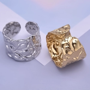 Detail of irregular hammered texture on gold and silver wide band open rings