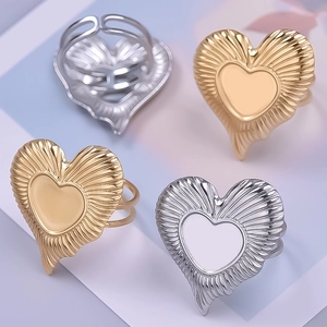 Detailed close-up of 18K gold and silver heart rings with radial groove textures