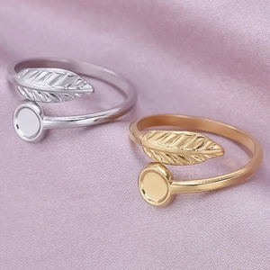 Detail of adjustable gold and silver leaf rings on soft purple fabric background