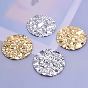 Detailed view of hammered texture on gold and silver stainless steel round pendants