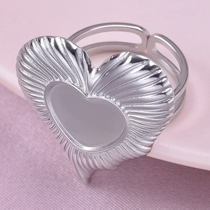 Macro detail of silver heart ring with sunburst texture and split band design