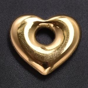Détail macro d'un pendentif cœur évidé en acier inoxydable 304 avec fini doré