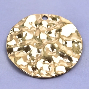 Macro shot of gold-plated 304 stainless steel round pendant with hammered texture detail