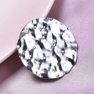 Macro shot of silver 304 stainless steel round pendant with hammered texture detail
