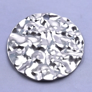 Detailed macro view of silver 304 stainless steel pendant with hammered metal texture