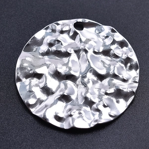 Macro view of a 304 stainless steel round pendant with hammered texture and silver finish