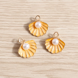Colgante de concha esmaltada naranja con perla blanca e incrustación de metal dorado