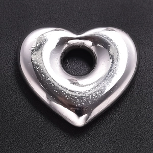 Gros plan d'un pendentif cœur argenté avec finition texturée pour création de bijoux