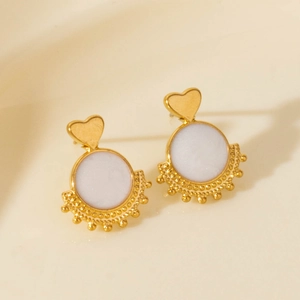 Exaggerated golden heart earrings with round white enamel inlay and beaded details