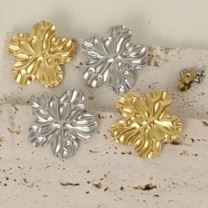 Dettaglio macro degli orecchini a foglia martellata in oro e argento su pietra naturale