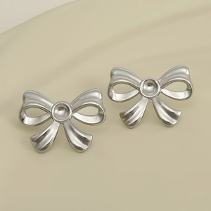 Detailed view of polished silver bow stud earrings with a sleek minimalist metallic finish