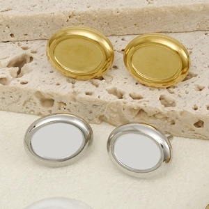 Orecchini a perno ovali minimalisti in oro e argento su sfondo di pietra naturale