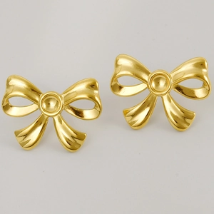 Detailed macro view of 304 stainless steel bow stud earrings with polished 18K gold finish