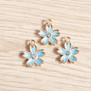 Close-up of blue enamel cherry blossom pendants with gold plating and zircon center