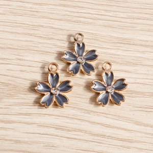 Close-up of cherry blossom flower pendants with grey enamel and central crystal accents