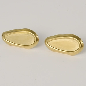 Detail showing dual texture finish with polished edges and matte center on gold pebble earrings