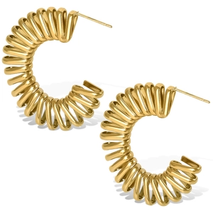 Détail macro des boucles d'oreilles spirale dorées en C avec une finition miroir polie