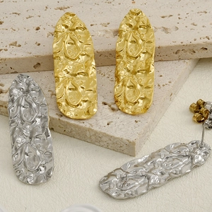 Macro detail of irregular pleated texture on gold and silver 304 stainless steel earrings