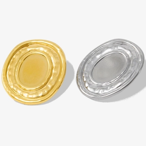 Detailed macro view showing the textured oval surface of gold and silver steel earrings